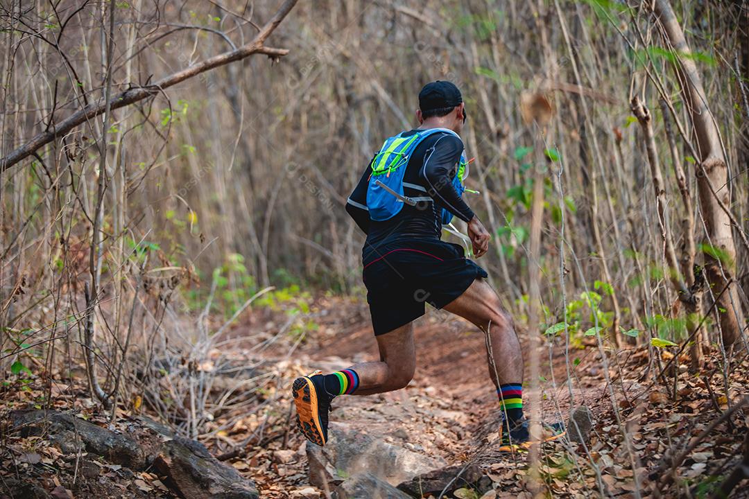 Um homem corredor de trilha. e pés de atleta usando sapatos esportivos para trilha na floresta