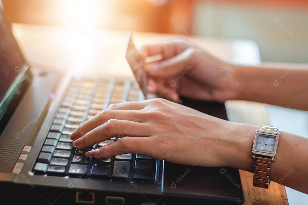 mulher asiática usando laptop e cartão de crédito compras on-line, foco seletivo na mão, foco suave e tom vintage