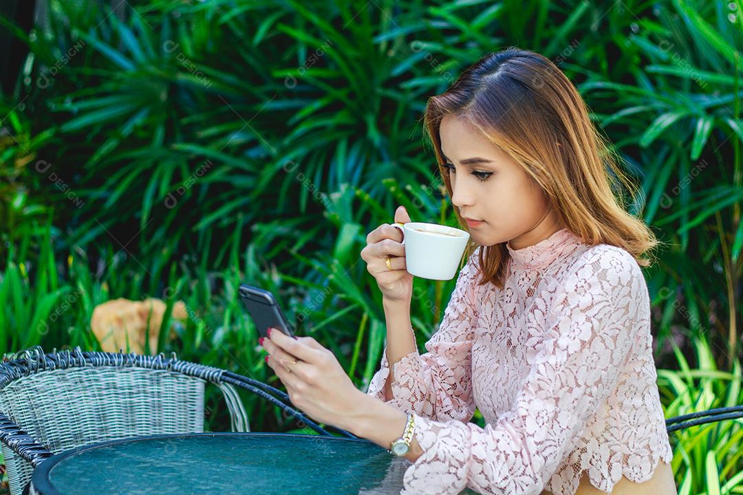 Empresários e mulheres estão usando telefone inteligente móvel e sensível ao toque para comunicação e verificando pessoas de negócios no fundo do escritório