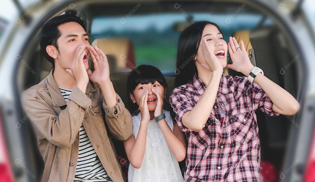Menina feliz com família asiática sentada no carro para curtir a viagem e as férias de verão na van campista