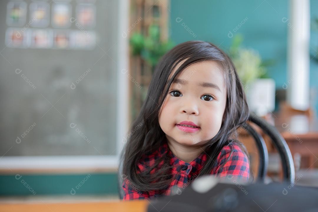 Menina bonitinha asiática sentada sorrindo
