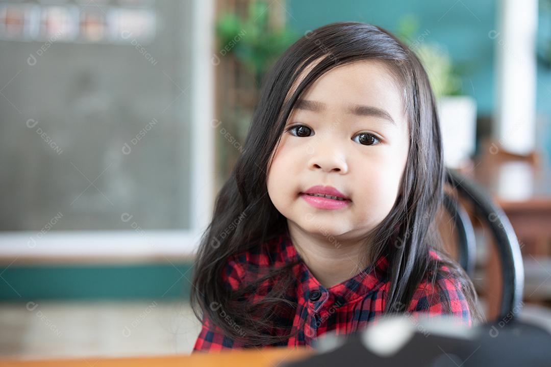Menina bonitinha asiática sentada sorrindo