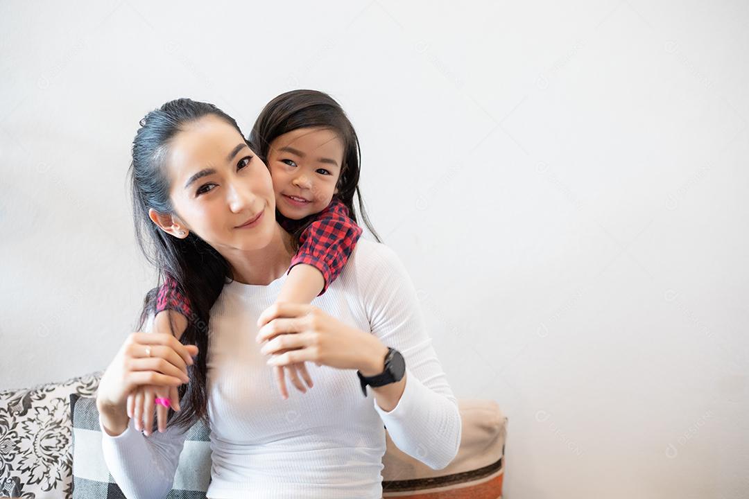 A filha está abraçando a mãe e rindo feliz