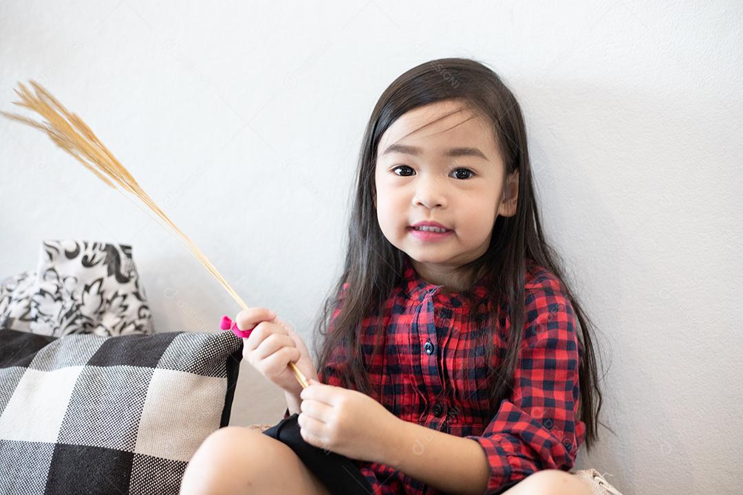 Menina bonitinha asiática sentada sorrindo