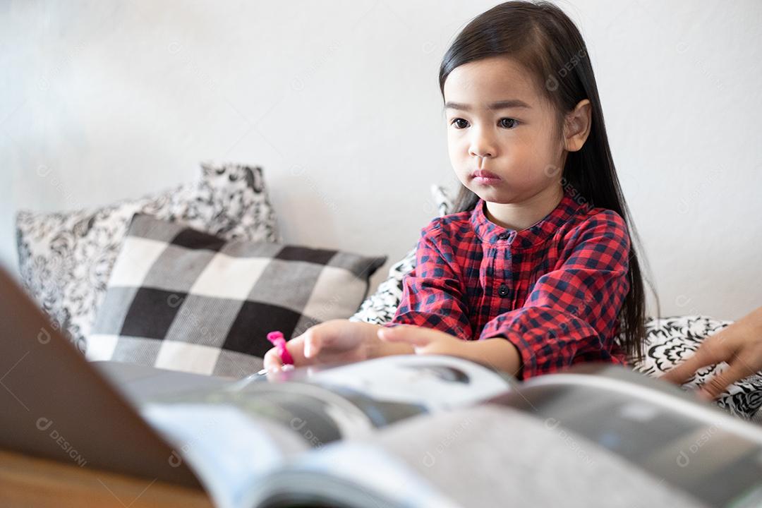 Filha está assistindo e jogando notebook