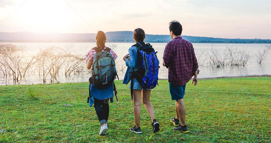 Grupo asiático de jovens Caminhando com mochilas de amigos caminhando juntos e olhando o mapa e tirando a câmera fotográfica pela estrada e parecendo feliz, Relaxe o tempo em viagens de conceito de férias