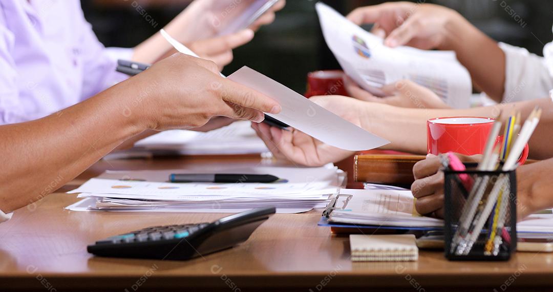 Documentos de análise de empresárias asiáticas na mesa de escritório com computador portátil e diagrama financeiro gráfico trabalhando em segundo plano