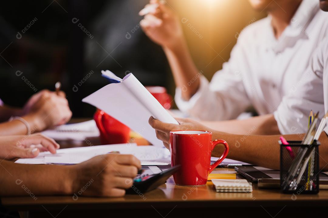 Documentos de análise de empresárias asiáticas na mesa de escritório com computador portátil e diagrama financeiro gráfico trabalhando em segundo plano