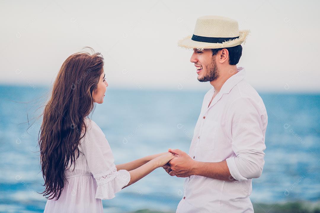 Feliz amante de casais românticos de mãos dadas caminhando na praia