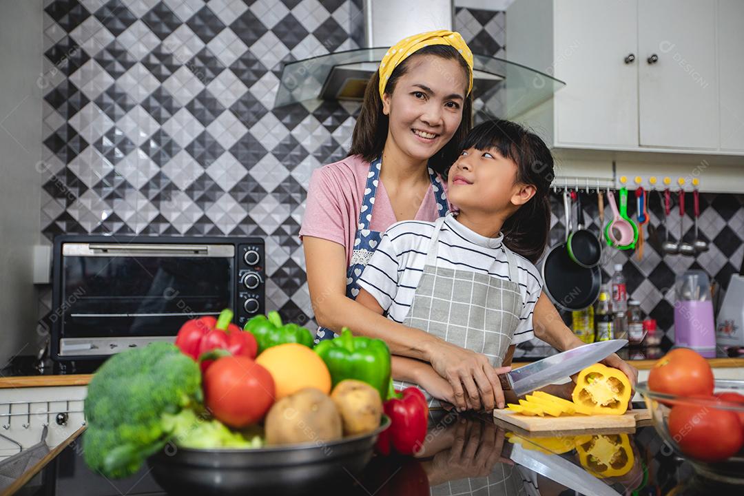 Família feliz tem papai, mamãe e sua filhinha cozinhando juntos na cozinha