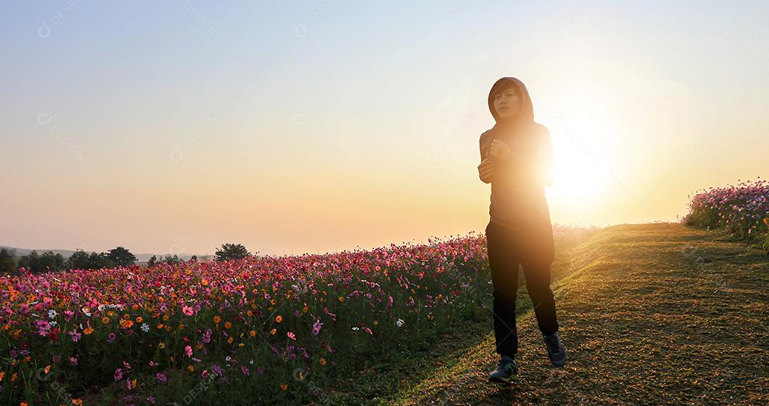 Mulheres asiáticas correndo de manhã no campo de flores do cosmos foco suave e embaçado