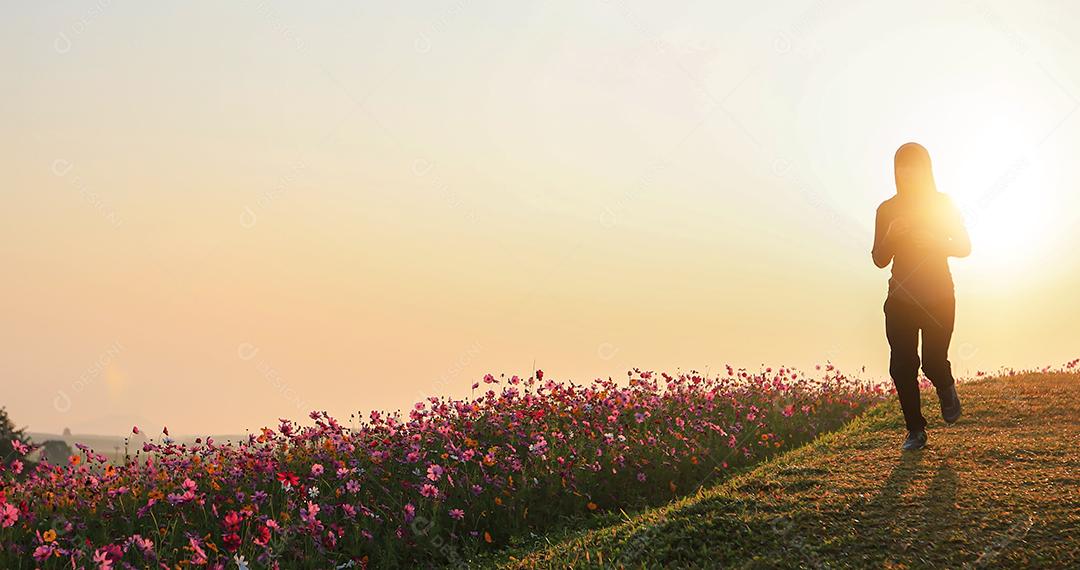 Mulheres asiáticas correndo de manhã no campo de flores do cosmos foco suave e embaçado