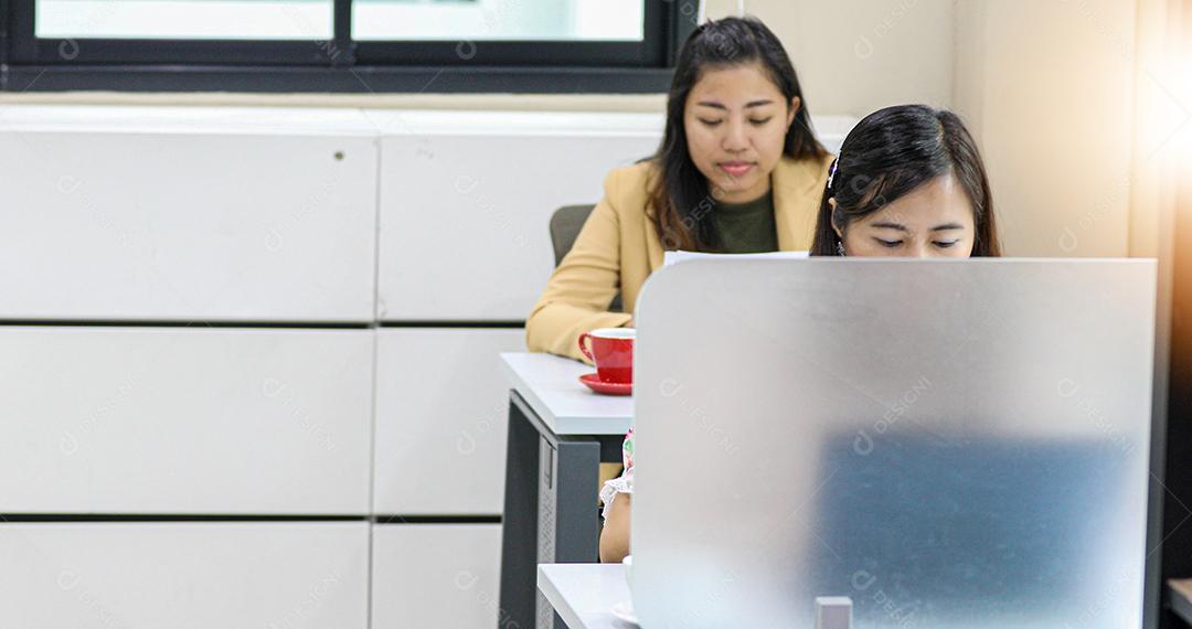 Empresária asiática séria sobre o trabalho e usando notebook para parceiros de negócios discutindo documentos e ideias na reunião