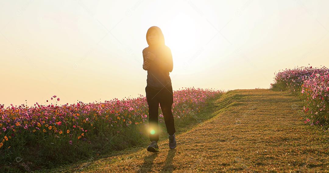 Mulheres asiáticas correndo de manhã no campo de flores do cosmos foco suave e embaçado
