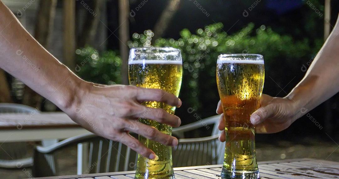 Grupo asiático de amigos festejando com bebidas alcoólicas de cerveja e jovens desfrutando em um bar brindando coquetéis e copos tinindo