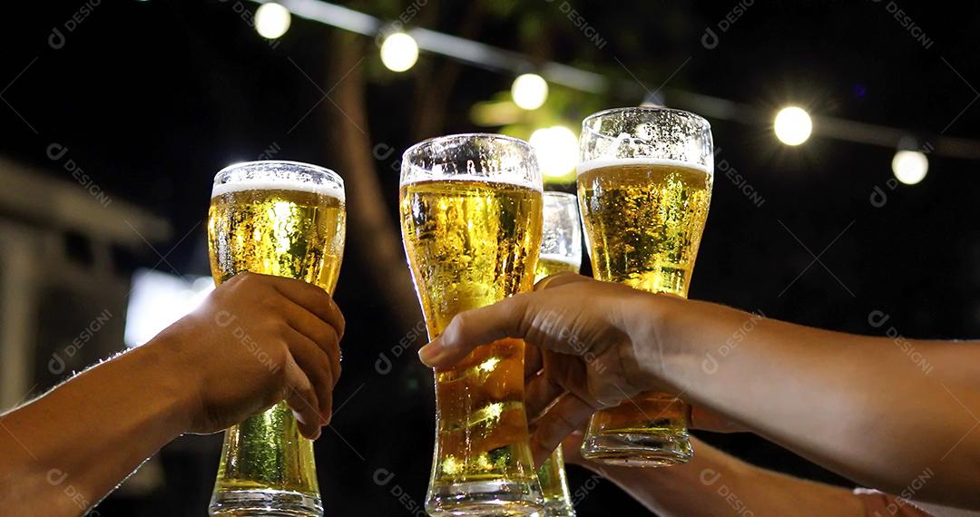 Grupo asiático de amigos festejando com bebidas alcoólicas de cerveja e jovens desfrutando em um bar brindando coquetéis e copos tinindo