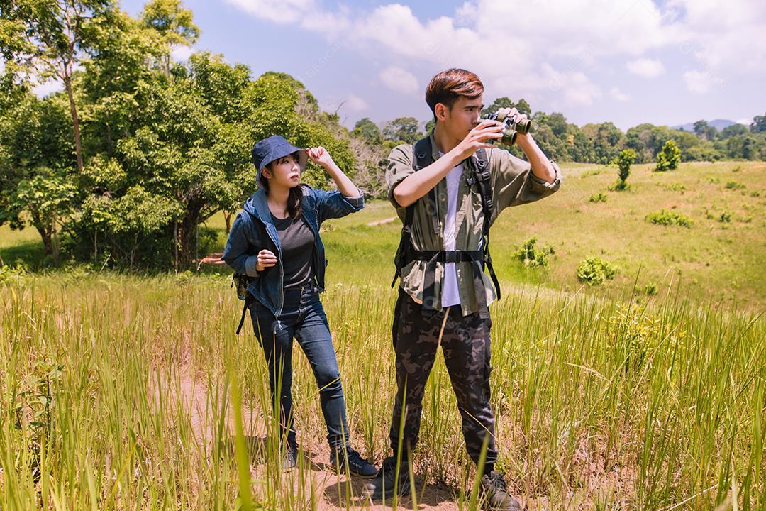 Grupo asiático de jovens Caminhando com mochilas de amigos caminhando juntos e olhando o mapa e tirando a câmera fotográfica pela estrada e parecendo feliz, Relaxe o tempo em viagens de conceito de férias