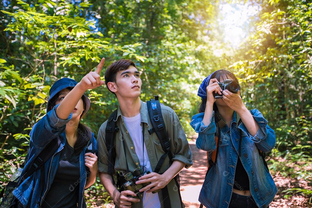 Grupo asiático de jovens Caminhando com mochilas de amigos caminhando juntos e olhando o mapa e tirando a câmera fotográfica pela estrada e parecendo feliz, Relaxe o tempo em viagens de conceito de férias