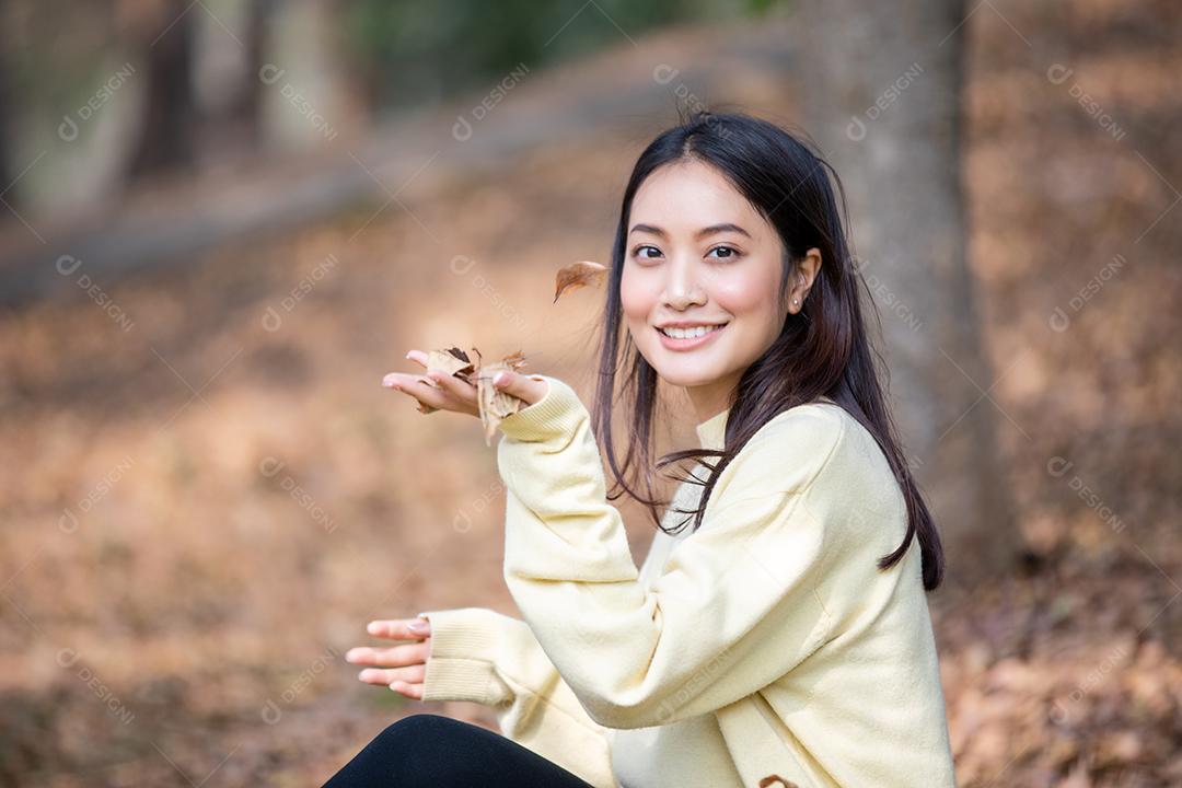 Linda mulher asiática sorrindo feliz e vestindo roupas quentes retrato de inverno e outono ao ar livre no parque