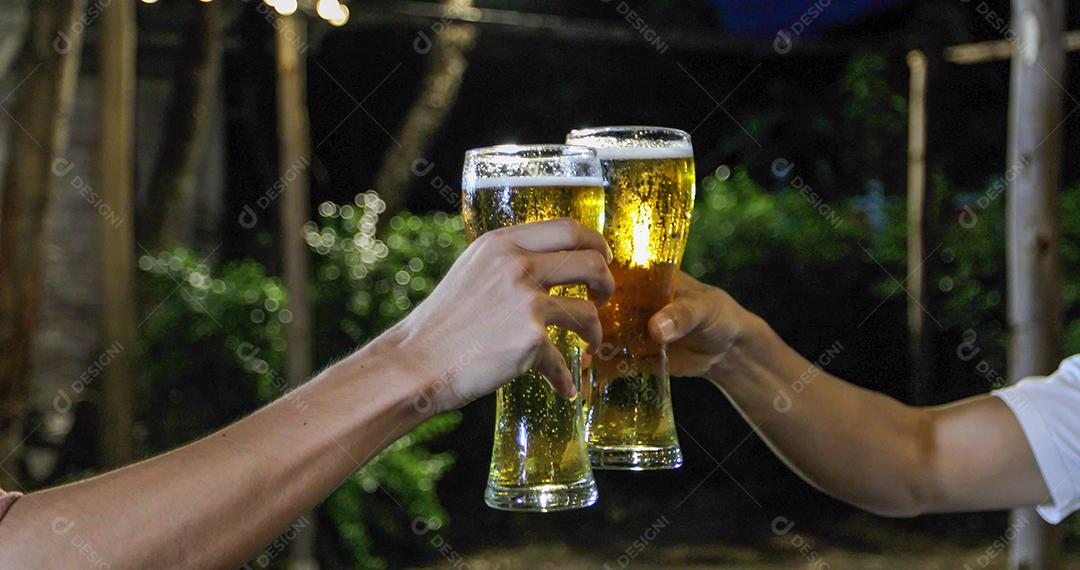 Grupo asiático de amigos festejando com bebidas alcoólicas de cerveja e jovens desfrutando em um bar brindando coquetéis e copos tinindo