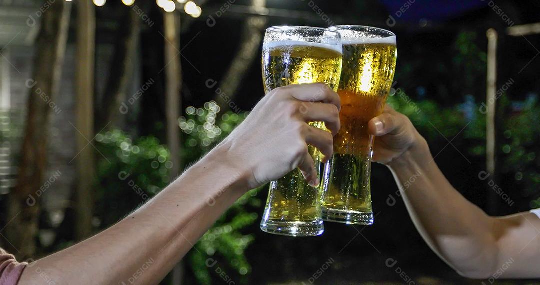 Grupo asiático de amigos festejando com bebidas alcoólicas de cerveja e jovens desfrutando em um bar brindando coquetéis e copos tinindo