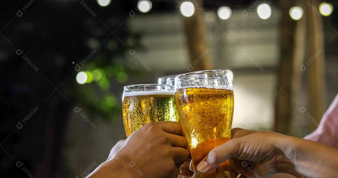 Grupo asiático de amigos festejando com bebidas alcoólicas de cerveja e jovens desfrutando em um bar brindando coquetéis e copos tinindo