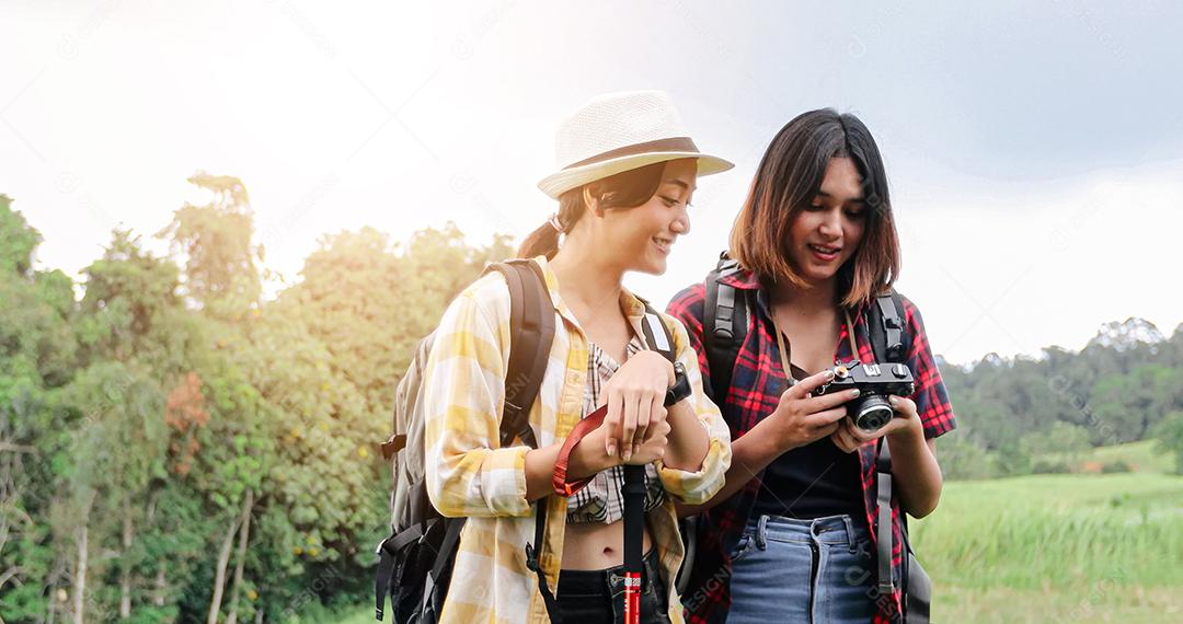 Grupo asiático de jovens Caminhando com mochilas de amigos caminhando juntos e olhando o mapa e tirando a câmera fotográfica pela estrada e parecendo feliz, Relaxe o tempo em viagens de conceito de férias