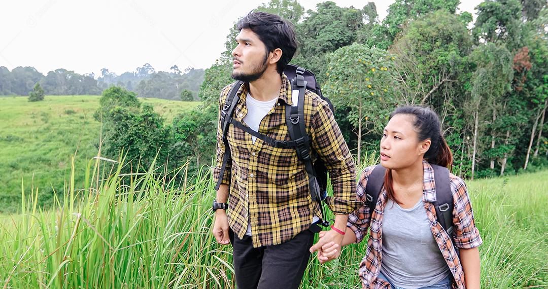 Grupo asiático de jovens Caminhando com mochilas de amigos caminhando juntos e olhando o mapa e tirando a câmera fotográfica pela estrada e parecendo feliz, Relaxe o tempo em viagens de conceito de férias