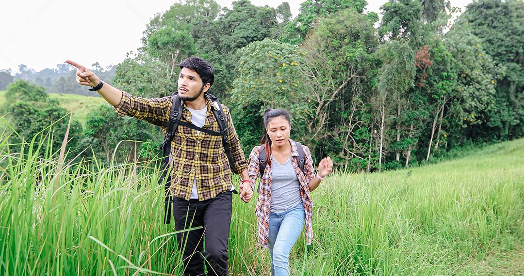 Grupo asiático de jovens Caminhando com mochilas de amigos caminhando juntos e olhando o mapa e tirando a câmera fotográfica pela estrada e parecendo feliz, Relaxe o tempo em viagens de conceito de férias