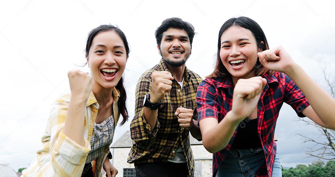 Jovens estudantes bem sucedidos no campus olhando para a câmera e sorrindo e mais cinco enquanto pulando ao ar livre.