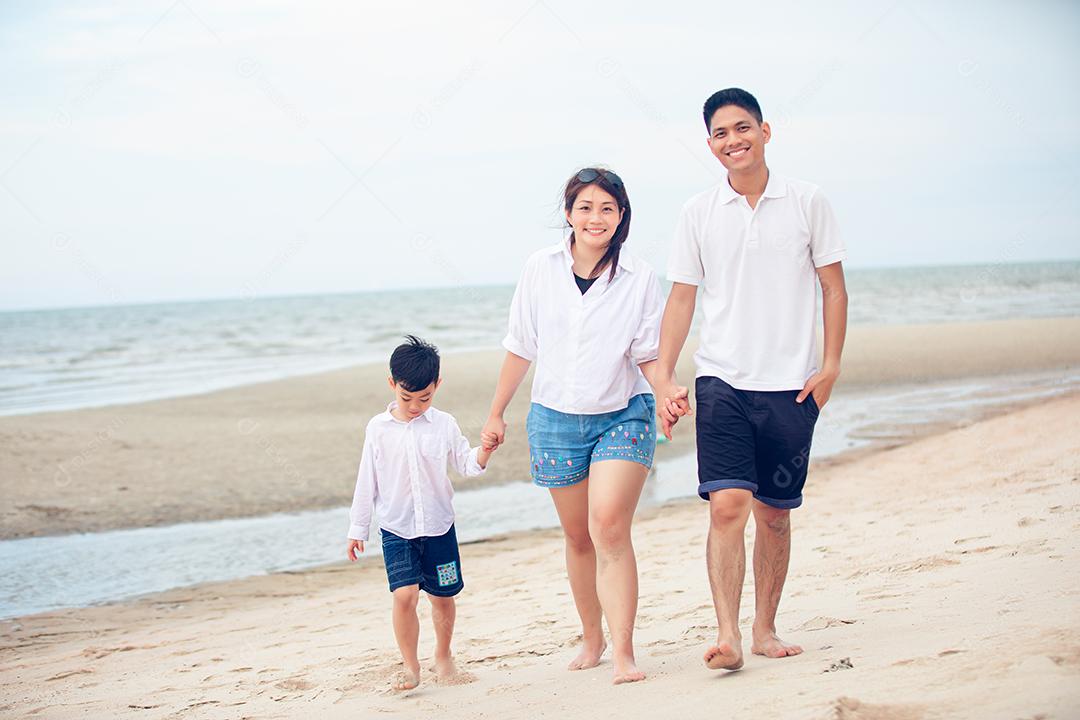 Pais ativos e atividades ao ar livre de pessoas nas férias de verão e férias com crianças. Família e filho felizes andam com diversão do mar do sol na praia de areia.