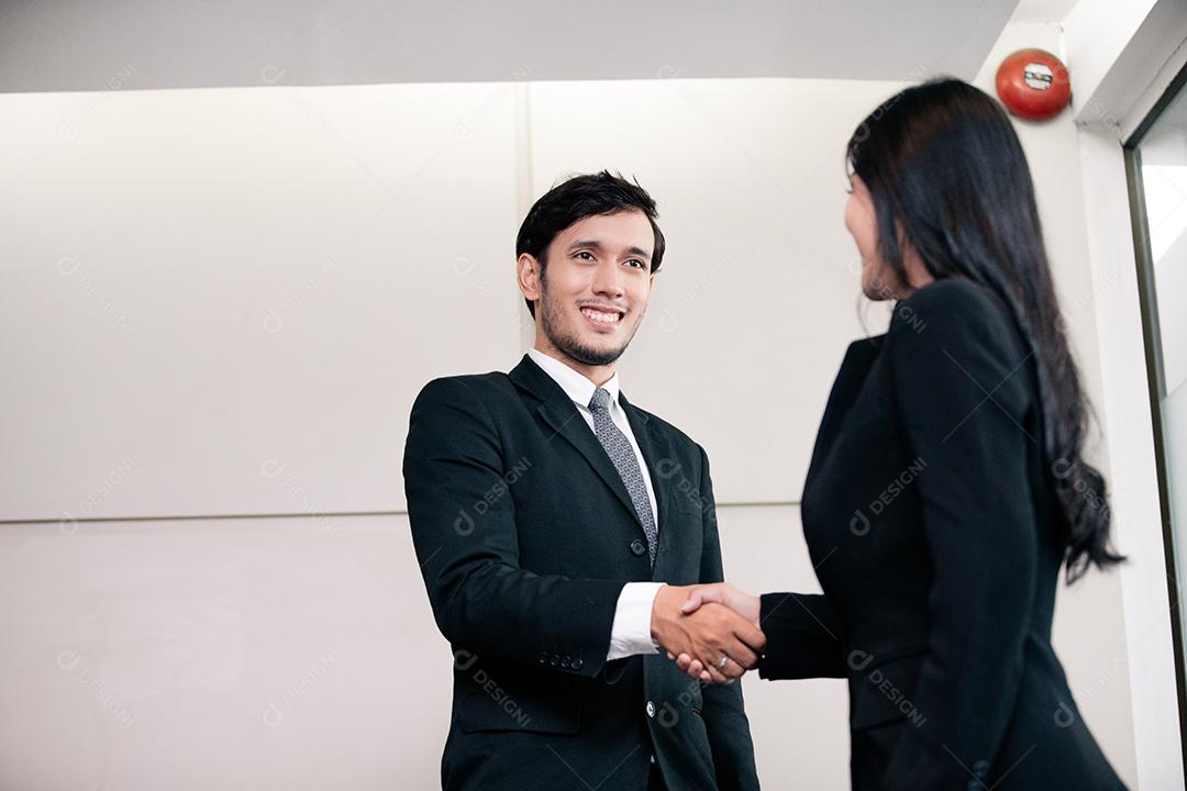 Empresários apertando as mãos e sorrindo seu acordo para assinar contrato e terminar uma reunião