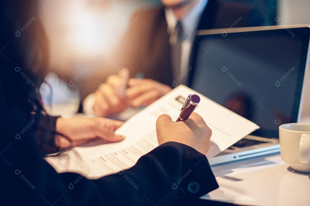 Empresários e empresárias discutindo documentos e assinando um acordo comercial para o conceito de entrevista de emprego
