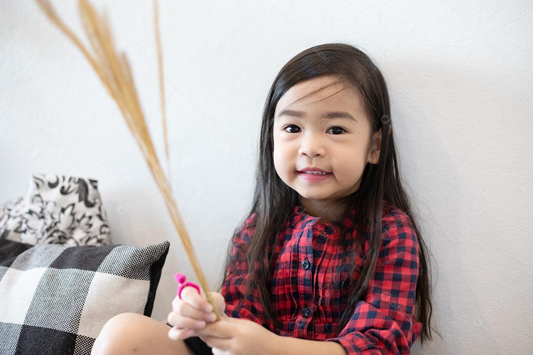 Menina bonitinha asiática sentada sorrindo