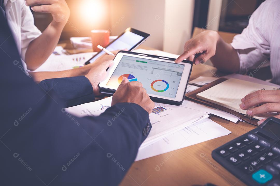 Empresárias asiáticas usando tablet para documentos de análise e diagrama financeiro gráfico trabalhando em reunião