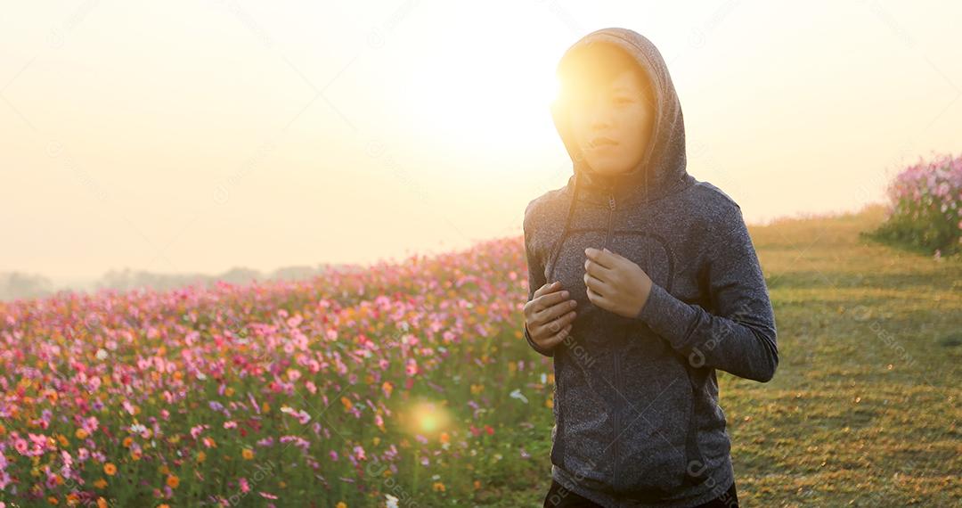 Mulheres asiáticas correndo de manhã no campo de flores do cosmos