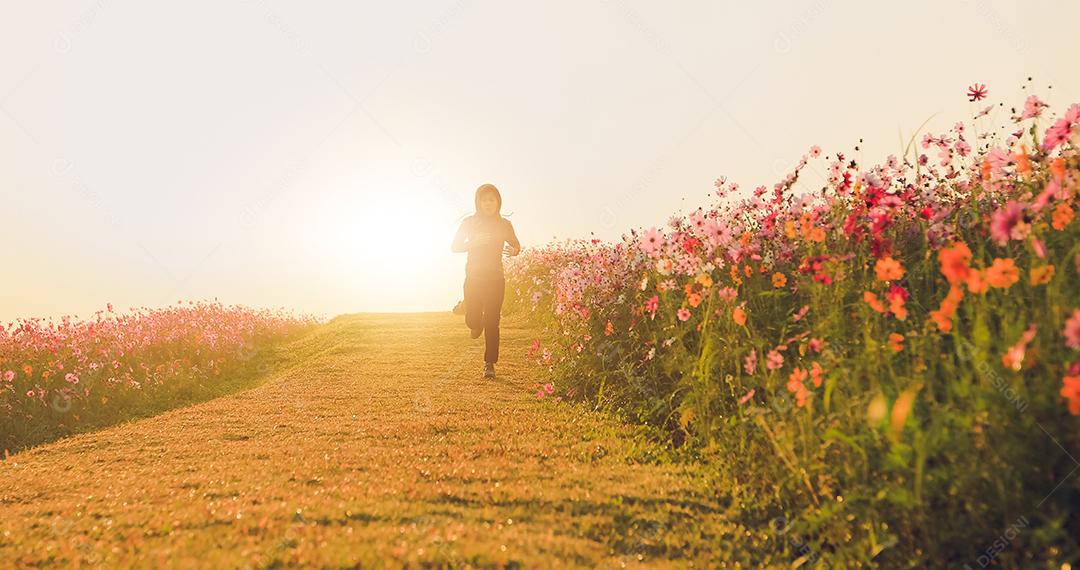 Mulheres asiáticas correndo de manhã no campo de flores do cosmos