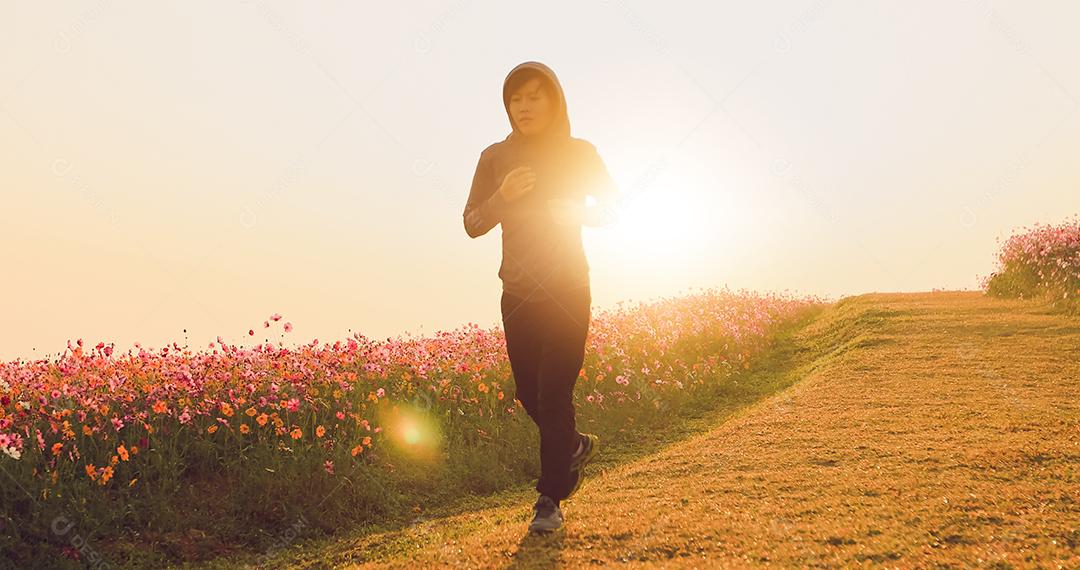Mulheres asiáticas correndo de manhã no campo de flores do cosmos
