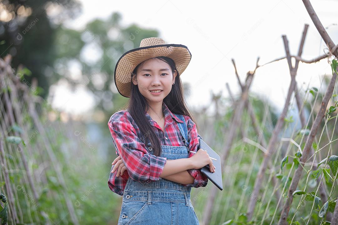 Mulheres da Ásia Agrônoma e agricultora usando tecnologia para inspecionar em campo de vegetais agrícolas e orgânicos