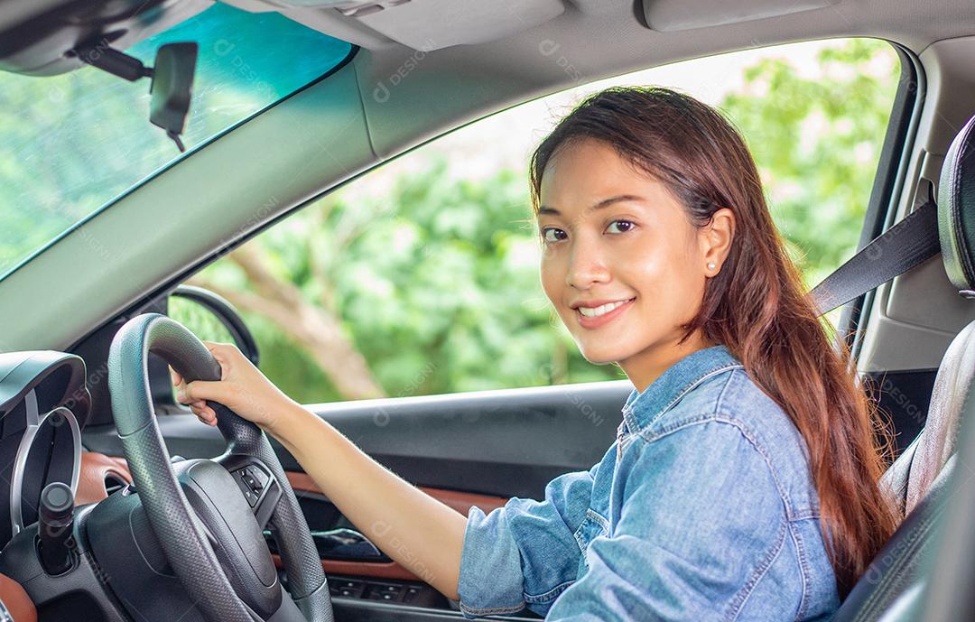 Linda mulher asiática sorrindo e se divertindo dirigindo um carro na estrada para viajar