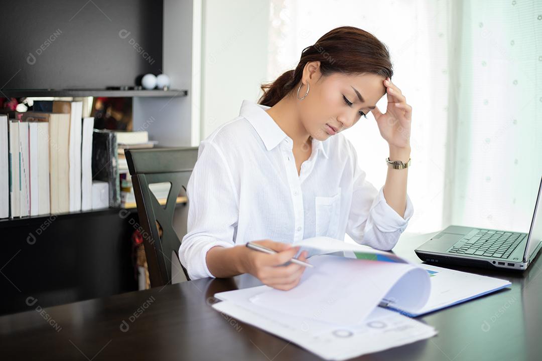 Mulher de negócios asiática séria e dor de cabeça sobre o trabalho duro e o uso do notebook