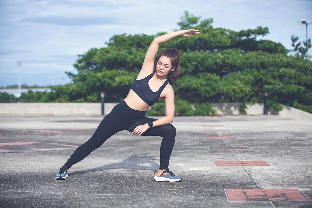 Mulher atlética asiática se aquecendo e jovem atleta sentada em um exercício e alongamento em um parque antes do corredor ao ar livre, conceito de estilo de vida saudável