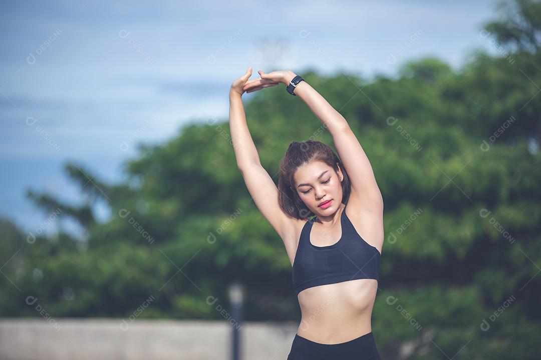 Mulher atlética asiática se aquecendo e jovem atleta sentada em um exercício e alongamento em um parque antes do corredor ao ar livre, conceito de estilo de vida saudável