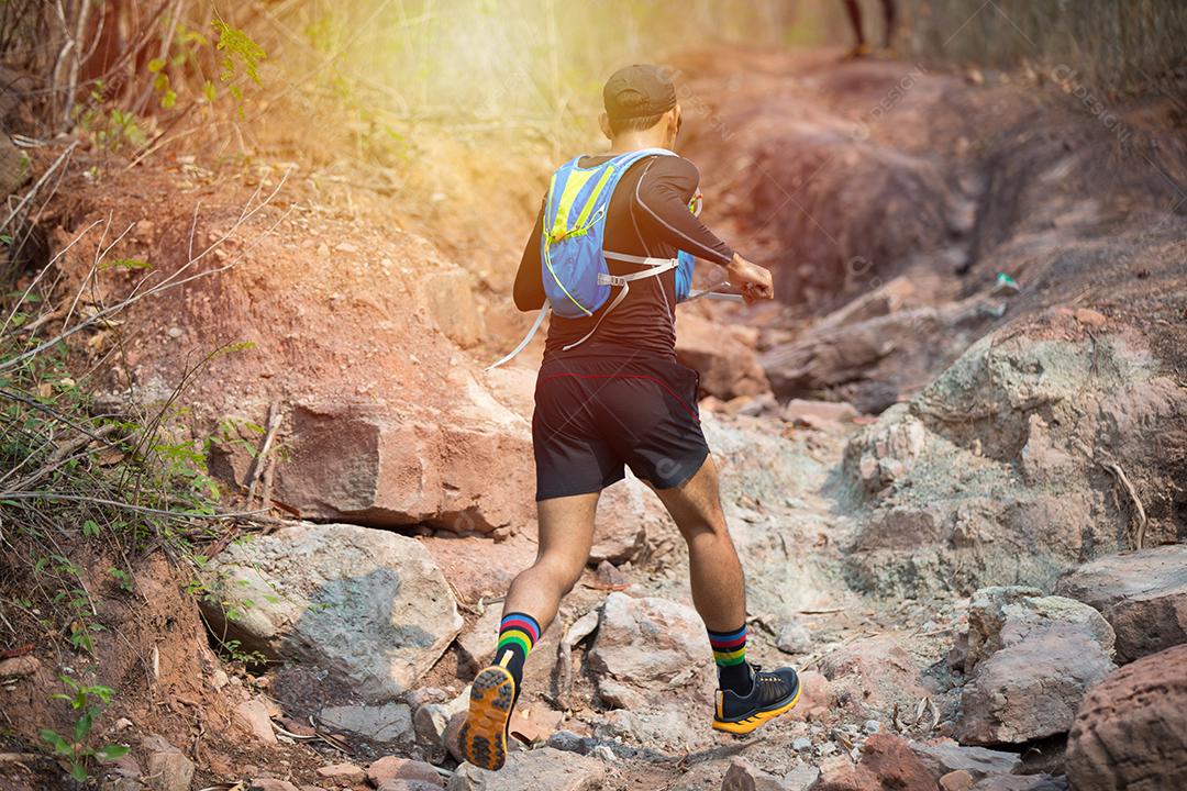 Um homem Runner of Trail e pés de atleta usando sapatos esportivos para trilha na floresta