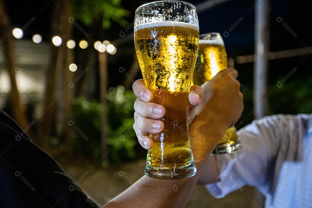 Grupo asiático de amigos festejando com bebidas alcoólicas de cerveja e jovens desfrutando em um bar brindando coquetéis e copos tinindo