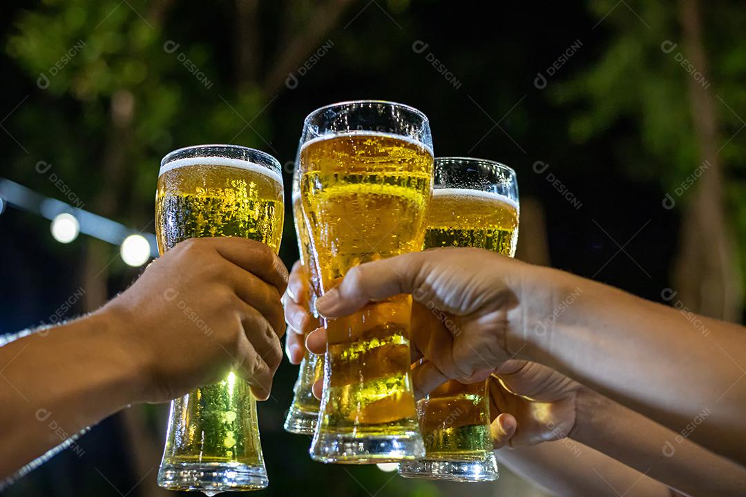 Grupo asiático de amigos festejando com bebidas alcoólicas de cerveja e jovens desfrutando em um bar brindando coquetéis e copos tinindo