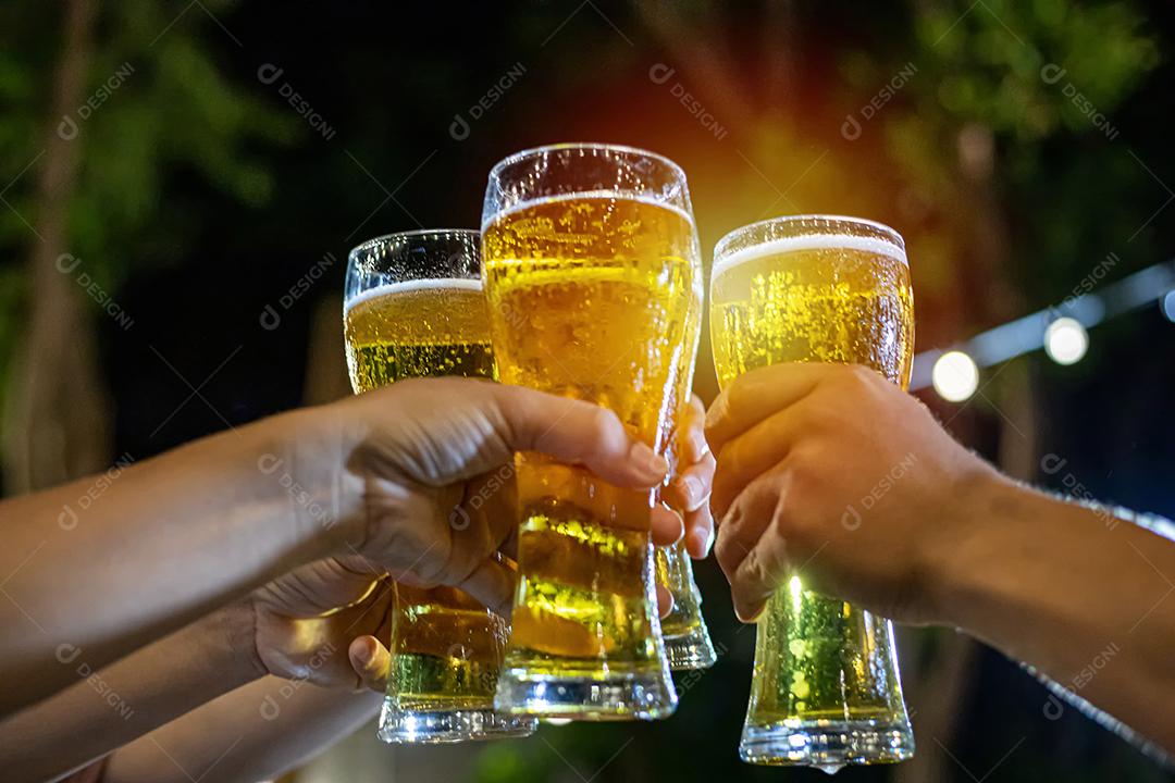 Grupo asiático de amigos festejando com bebidas alcoólicas de cerveja e jovens desfrutando em um bar brindando coquetéis e copos tinindo