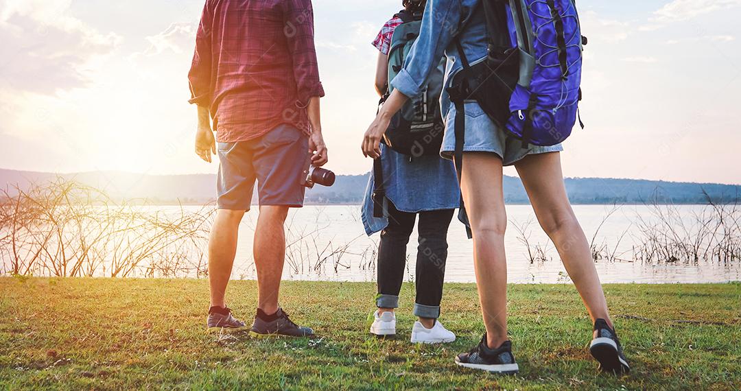Grupo asiático de jovens Caminhando com mochilas de amigos caminhando juntos e olhando o mapa e tirando a câmera fotográfica pela estrada e parecendo feliz, Relaxe o tempo em viagens de conceito de férias