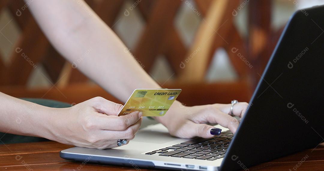 mulher asiática usando smartphone e cartão de crédito compras online