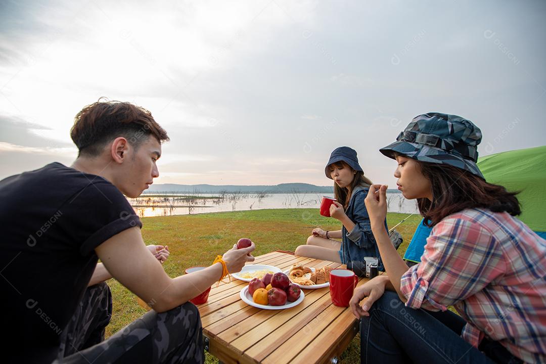 Grupo asiático de jovens Caminhando com mochilas de amigos caminhando juntos e olhando o mapa e tirando a câmera fotográfica pela estrada e parecendo feliz, Relaxe o tempo em viagens de conceito de férias